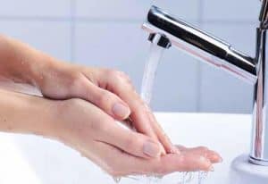 Hände werden unter fließendem Wasserim Waschbecken gereinigt - für eine effektive Händehygiene