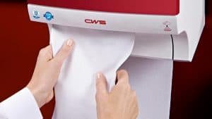 Stoffhandtuchspender rot, ausgezogene Stoffhandtuchrolle mit Frauenhänden