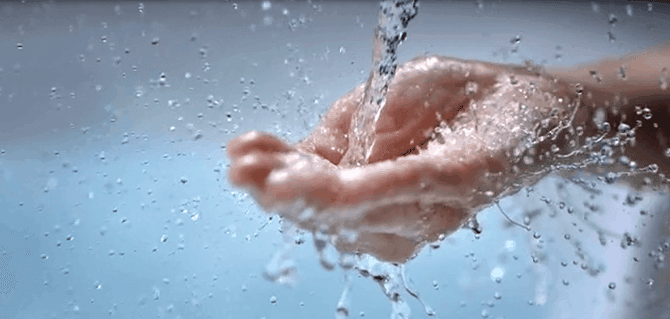 Wasser fließt aus dem Wasserhahn in die offene Hand