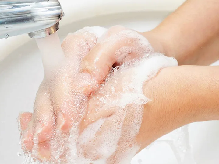 Hände mit Schaumseife unter fließendem Wasser - CleanUp-Mietservice