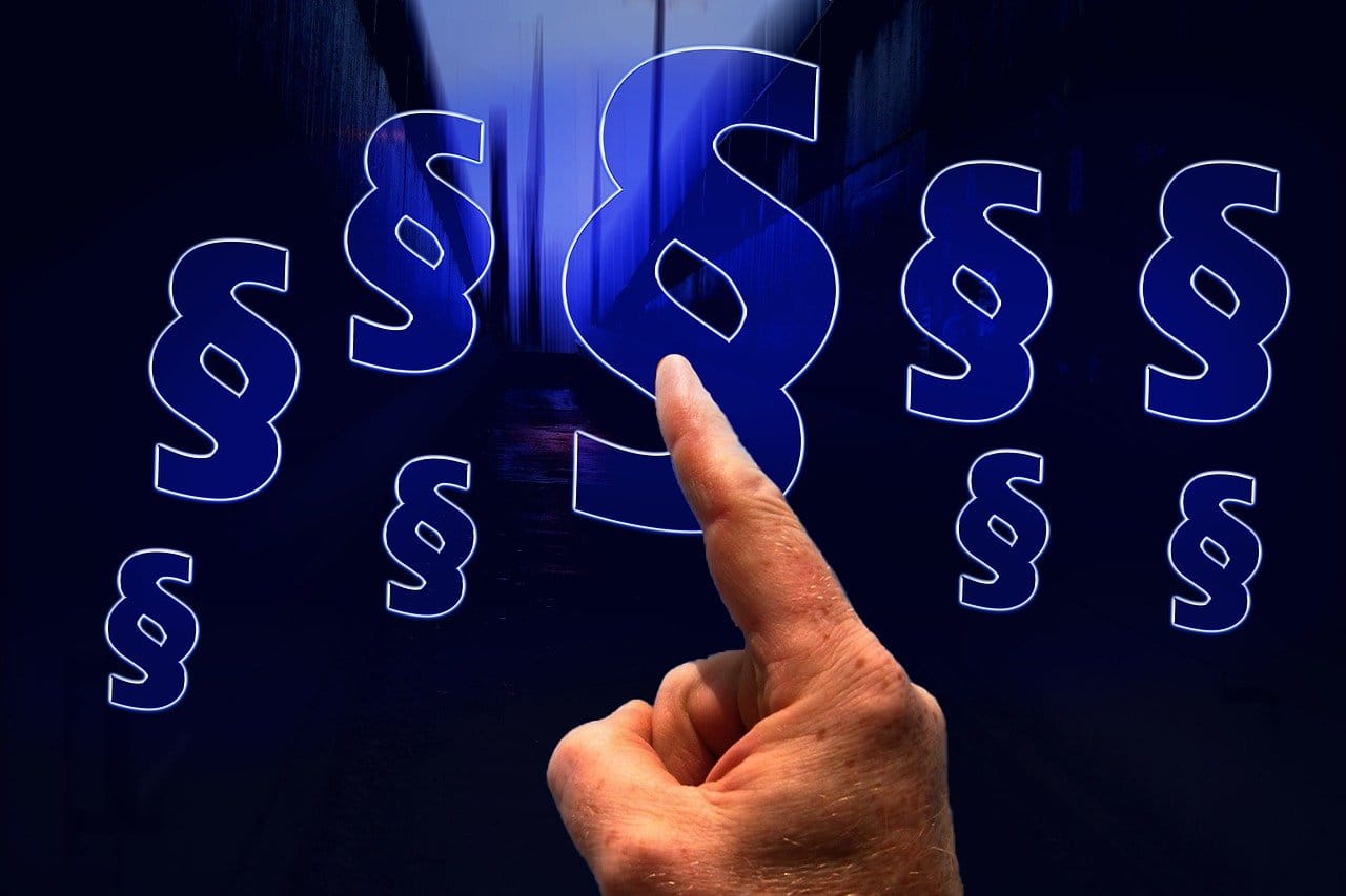 Paragraphenzeichen mehrfach auf duklem Hintergrung - Zeigefinger vorn (Hinweis)